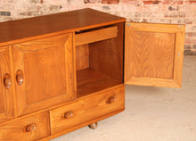Load image into Gallery viewer, A mid century Ercol Windsor elm sideboard on casters, circa 1960s