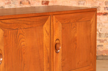 Load image into Gallery viewer, A mid century Ercol Windsor elm sideboard on casters, circa 1960s

