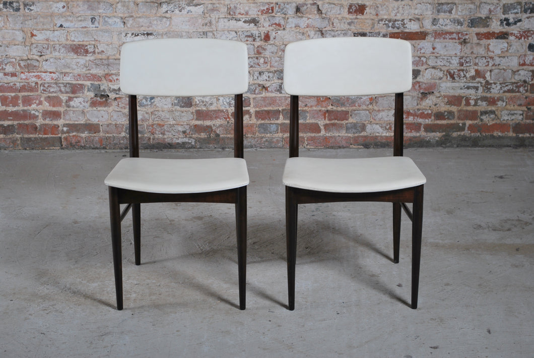 A pair of Mid Century dining chairs with original white vinyl upholstery, circa 1960s.